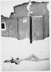 The corpse of a female prisoner lies in the snow outside a barrack at the Auschwitz-Birkenau extermination camp in Nazi-occupied Poland immediately after its liberation, January 1945. Photo credit: USHMM #58412